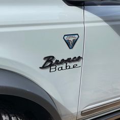 the back end of a white truck with black lettering on it's tailgate