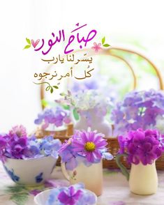 purple flowers are in white cups and saucers on a table with an arabic message