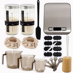 kitchen utensils, measuring cups and spoons are arranged in front of a scale