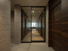 an empty hallway with glass doors leading to another room