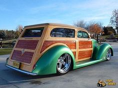 an old car with wood paneling and chrome rims parked in a parking lot