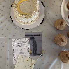 a table topped with cakes and cupcakes on top of a white table cloth