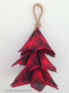 a red and black plaid christmas tree ornament hanging from a string on a white wall