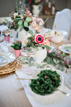 the table is set with flowers and plates