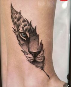 a close up of a person's foot with a tiger tattoo on the side