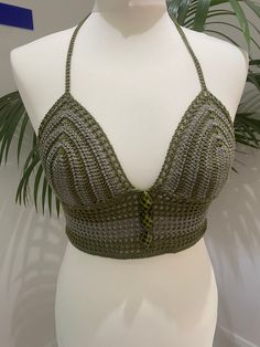 Handmade Two Tone Khaki Green Crochet Bralette Crop Top with adjustable tie back and bead embellishments This top is made with a beautiful high quality khaki yarn in two different shades, and features a fully adjustable halterneck tie, embellishments on the front and a fully adjustable tie up back.  Due to its customisable nature, this top would fit someone between the sizes of UK 6/8 to UK14, approximately A-C cup. Displayed on a UK size 8/10 mannequin. PLEASE NOTE - since this is a handmade item, its rather delicate so we recommend hand washing it only! Fitted Green Crochet Top For Festival, Green Fitted Crochet Top For Festival, Green Fitted Bohemian Halter Top, Adjustable Green Halter Top For Summer, Crochet Bralette, Green Crochet, Bralette Crop Top, Khaki Green, Tie Backs