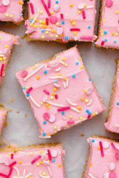 pink frosted cake squares with sprinkles on them