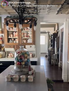 a cluttered kitchen with lots of jars on the counter and shelves full of candy