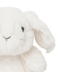 a white stuffed rabbit sitting up against a white background