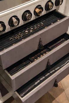 the drawers are organized with rings and bracelets on display in front of an oven