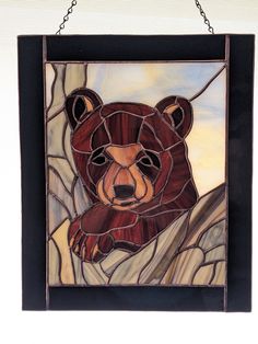 a stained glass bear hanging on a chain