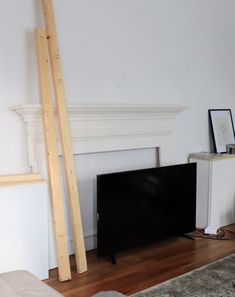 a flat screen tv sitting on top of a hard wood floor next to a fireplace