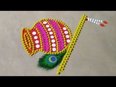 an artistic design made out of beads and thread on the floor, with colorful colors