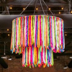 a multicolored chandelier hanging from the ceiling in a room with exposed lighting