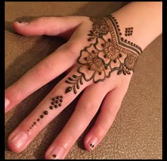 a woman's hand with henna tattoos on it