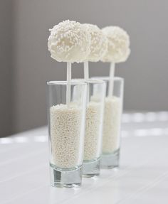 three glass vases filled with rice krispy kreme lollipops