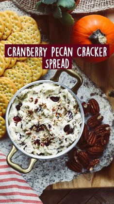 a bowl filled with whipped cream surrounded by crackers and pecans