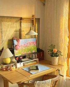 a wooden desk with a computer on top of it next to a lamp and window