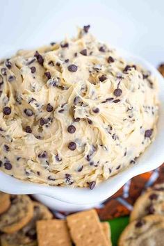 a white bowl filled with cookie dough and chocolate chip crackers on top of it