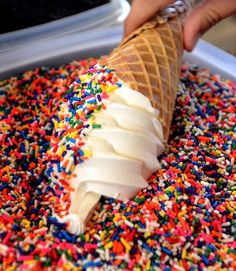 an ice cream cone with sprinkles and white frosting