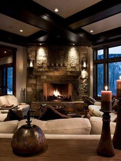 a living room filled with furniture and a fire place in front of a stone fireplace