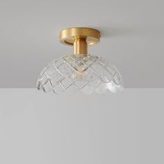 a glass light fixture hanging from the ceiling