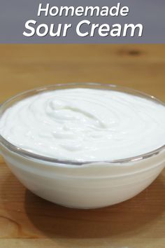 a bowl of sour cream sitting on top of a wooden table with the words homemade sour cream