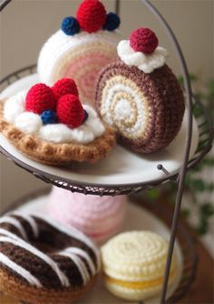 three crocheted pastries sitting on top of a cake stand