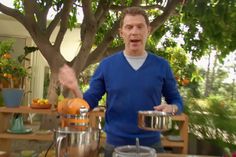 a man standing in front of a table with oranges and other food items on it