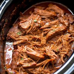 shredded meat in a slow cooker with brown sauce