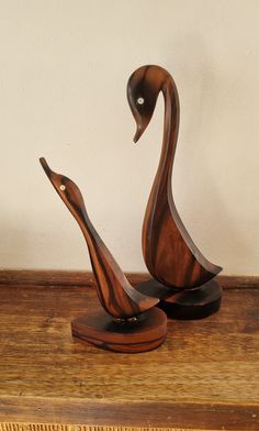 two wooden sculptures sitting on top of a table