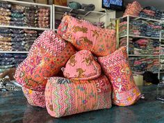 a pile of pillows sitting on top of a table in front of a television screen