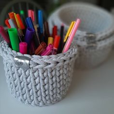 a basket filled with lots of different colored pens and markers on top of a table