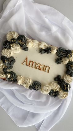 a cake with the word aman on it sitting on top of a white table cloth