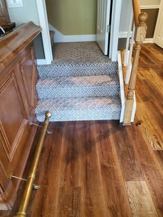 a wooden staircase leading up to an open door in a home with hard wood floors