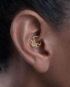 a woman's ear is shown with a small gold nose ring in the shape of a flower