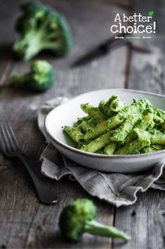 broccoli is in a white bowl on a wooden table