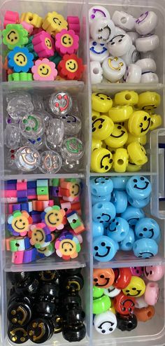 several plastic toys are arranged in an organized bin with smiley faces and other toy items