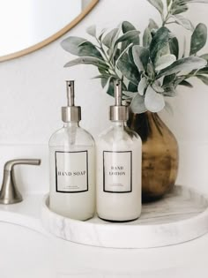 two soap dispensers sitting on top of a bathroom counter next to a mirror