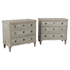 two white chests with gold knobs on each drawer and the tops are turned down