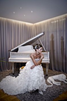 a woman in a wedding dress sitting at a piano