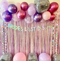 there are balloons and disco balls in front of the party backdrop that says bride's last sou