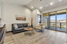 a living room filled with furniture next to a sliding glass door leading to a balcony