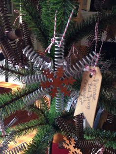 a close up of a christmas tree with ornaments on it and a sign hanging from the top