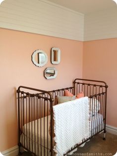 a baby crib in a pink room with mirrors on the wall