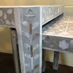 an artisticly designed table and bench made out of white marbles with leaves on it