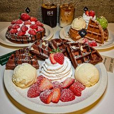 some waffles, strawberries and other desserts are on the table together