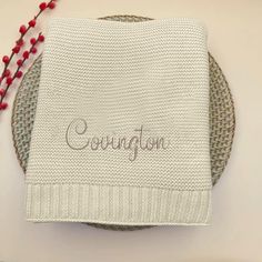 a white knitted dishcloth with the word congratulations on it and beads around it