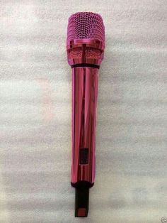 a pink microphone sitting on top of a white wall