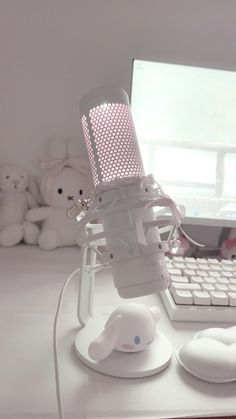 a microphone sitting on top of a desk next to a computer keyboard and teddy bears